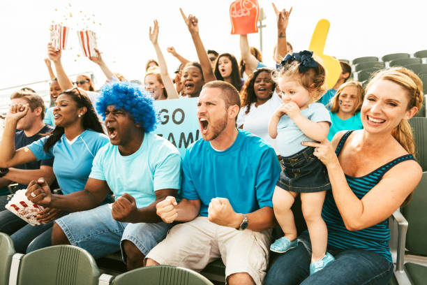 istock Crowd of fans cheering from stadium bleachers 664360104