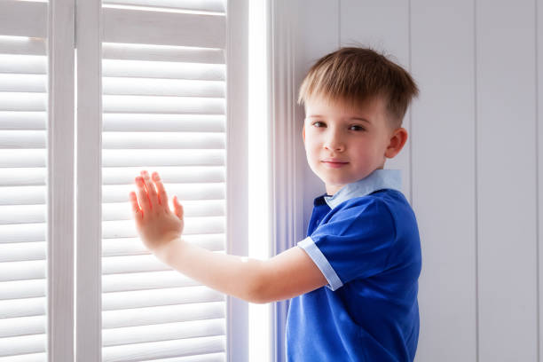 istock Portrait of a boy at a window 664363060