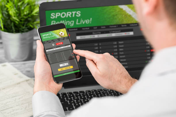 betting bet sport phone gamble laptop concept betting bet sport phone gamble laptop over shoulder soccer live home website concept - stock image sports betting stock pictures, royalty-free photos & images