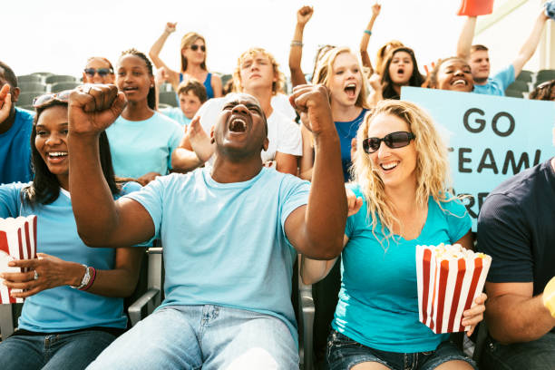 istock Crowd of fans cheering from stadium bleachers 664365284
