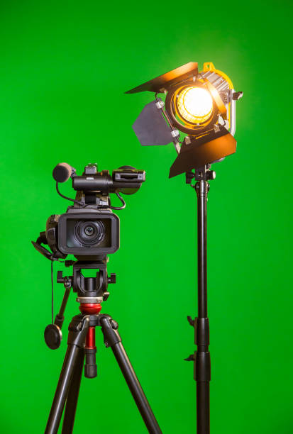une caméra vidéo et un projecteur avec une lentille de fresnel sur fond vert. filmer à l’intérieur. l’incrustation chrominance - fresnel photos et images de collection