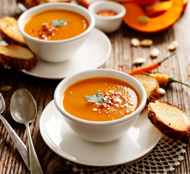 istock Pumpkin soup in a white ceramic bowl 664365732
