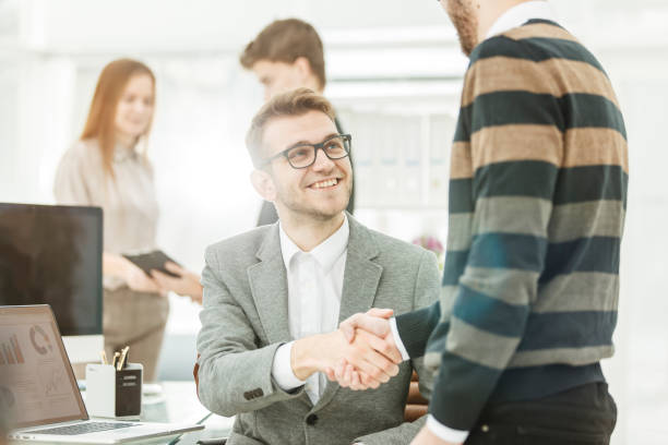 istock handshake colleagues near the workplace in the modern office 664370180
