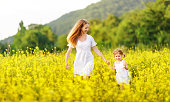 Happy family mother and child daughter running in  nature in summer