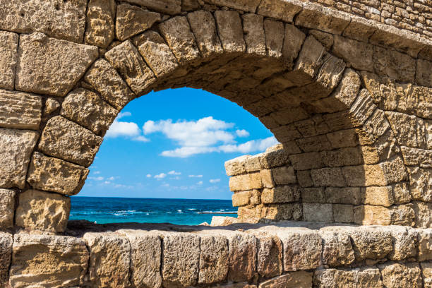 Stone arches and abutments of the Hadrianic aqueduct of Caesarea Maritima National Park along Israel's Mediterranean coast.