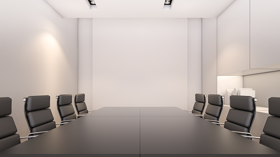 Meeting table set with white projector screen in conference room