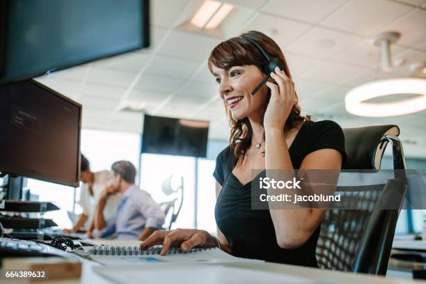Beautiful Mature Business Woman Talking On Headset Stock Photo - Download Image Now - Headset, Working, Computer
