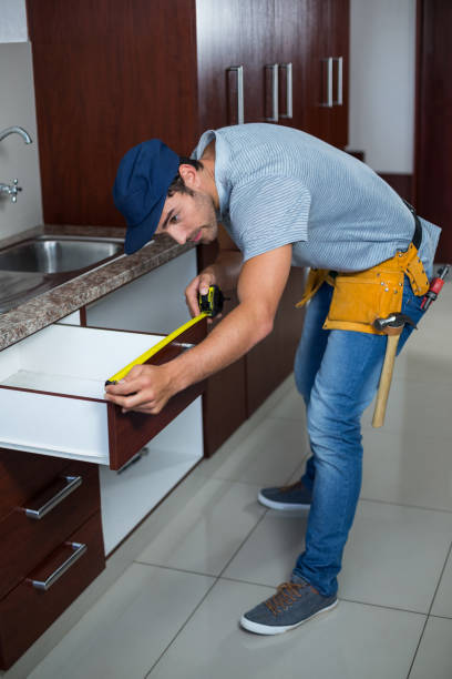 istock Full length of man measuring drawer size 664390378