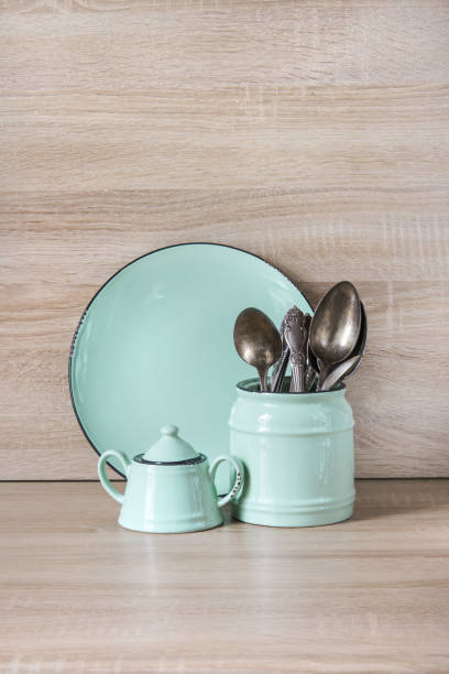 istock Turquoise crockery, tableware, dishware utensils and stuff on wooden table-top. Kitchen still life as background for design.  Image with copy space. 664393450