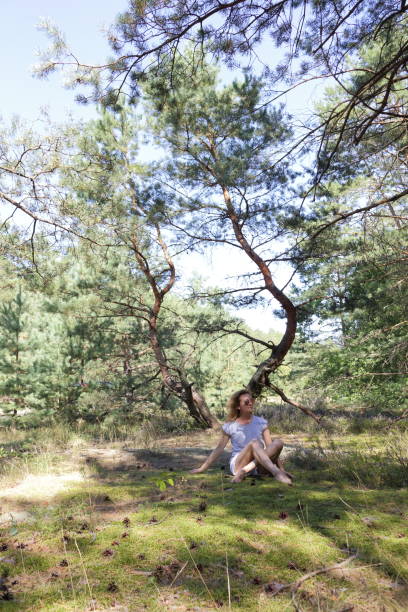 istock Woman is sitting in a pine tree forest. 664398752