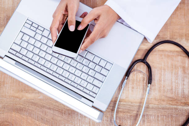 istock Doctor using smartphone on wooden desk 664399014