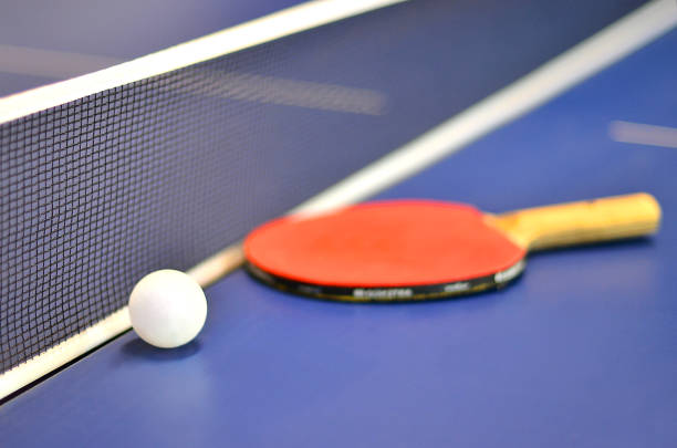 istock Pingpong racket and ball highlighted on a blue pingpong table 664403168