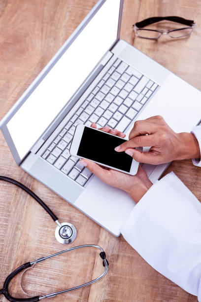 istock Doctor using smartphone on wooden desk 664406246
