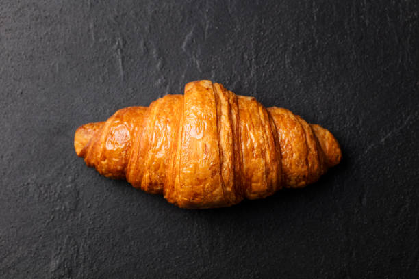 istock Fresh croissant on a black slate background. Top view. Copy space 664407420