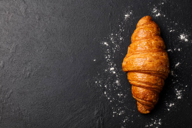 istock Fresh croissant on a black slate background. Top view. Copy space 664409618
