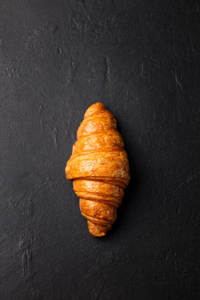 Fresh croissant on a black slate background. Top view. Copy space