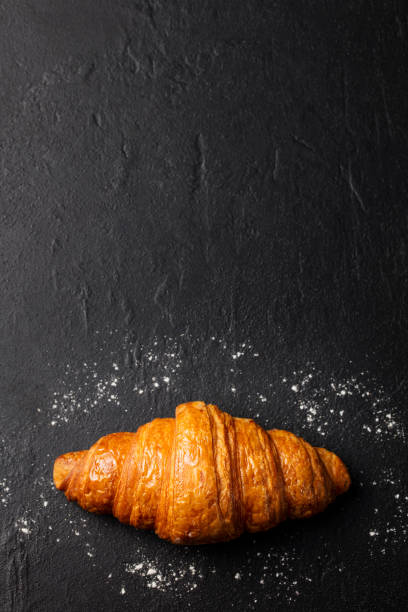 istock Fresh croissant on a black slate background. Top view. Copy space 664410050
