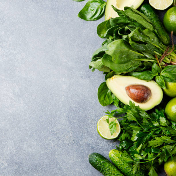 istock Green vegetables and herbs assortment on a grey stone background. Top view. Copy space 664410768