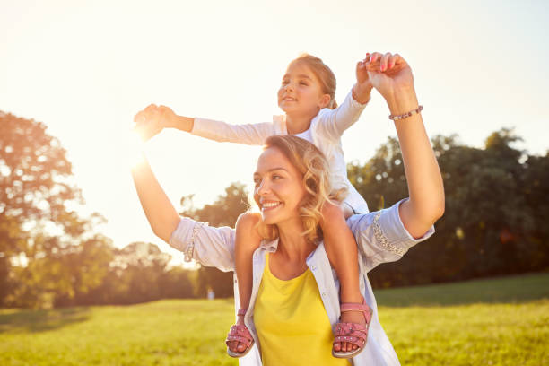istock Mom holding daughter on shoulders 664414090