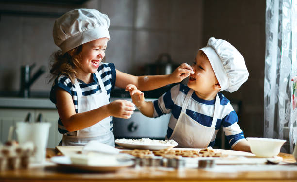 feliz familia funny kids hornear galletas en la cocina - christmas child cookie table fotografías e imágenes de stock