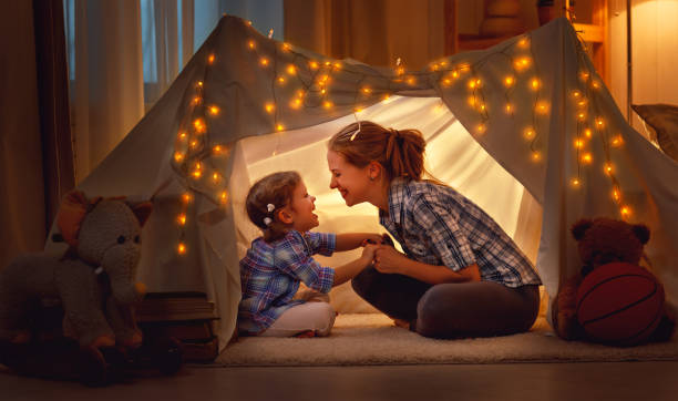 happy mother and daughter playing at home in tent happy family mother and daughter playing at home in a tent tent photos stock pictures, royalty-free photos & images