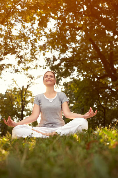 istock Lady in yoga pose in green nature 664421546