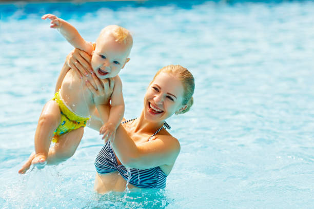 istock Mother and baby swim  in pool 664424650