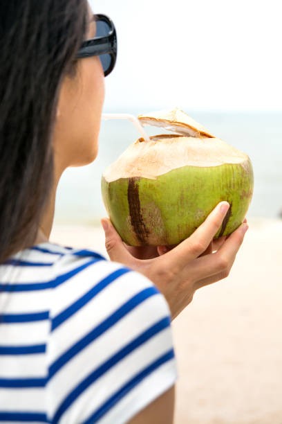 istock Girl with coconut on a beach 664430198