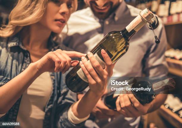 Couple At The Supermarket Stock Photo - Download Image Now - Wine, Wine Bottle, Shopping