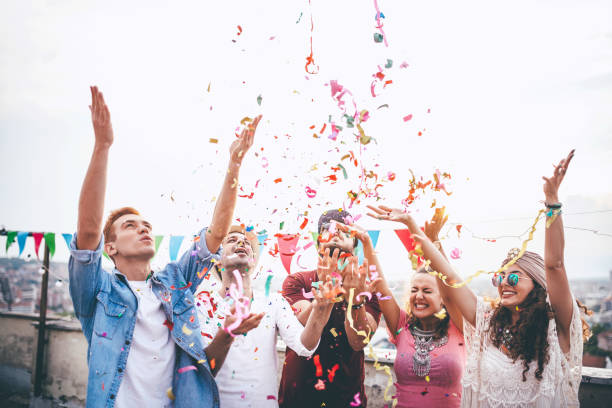 istock Joyful friends with confetti at the rooftop party 664442966