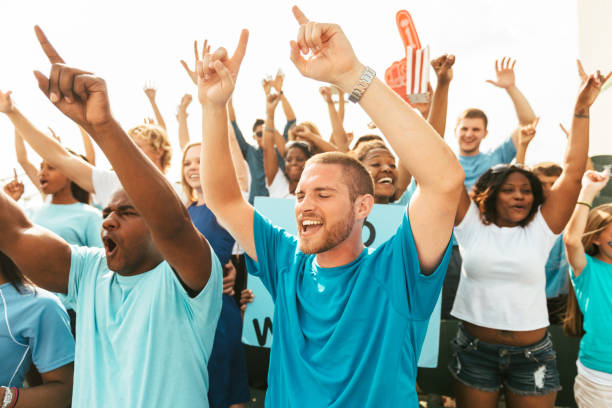 istock Crowd of fans cheering from stadium bleachers 664443678
