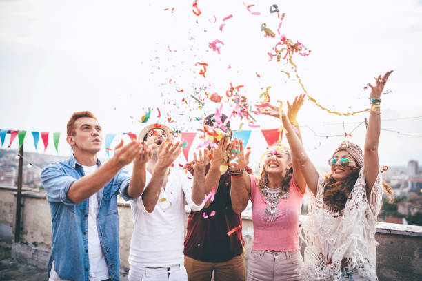 istock Joyful friends with confetti at the rooftop party 664443808