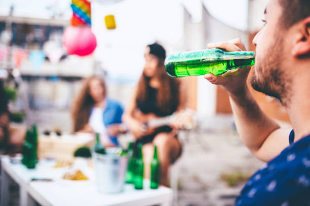 istock Man drinking beer on party with friends 664443816
