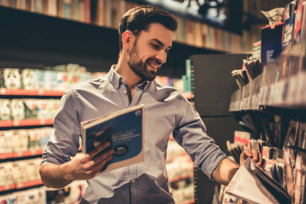 homme au supermarché - reading newspaper men magazine photos et images de collection