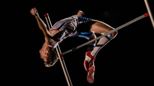 athlète masculin effectuant un saut en hauteur - high jump photos et images de collection