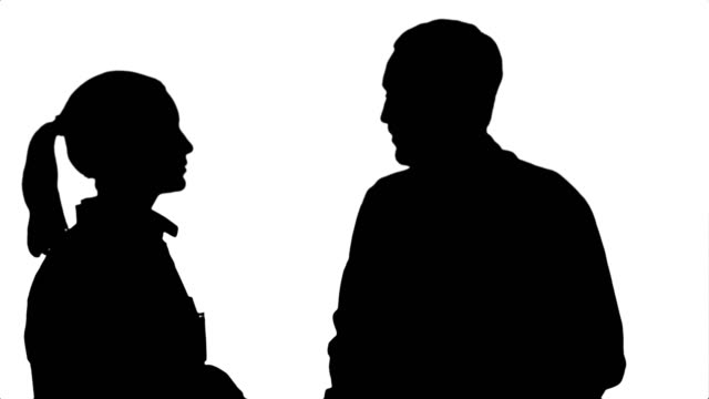 Silhouette Two medical professionals discuss with a patient