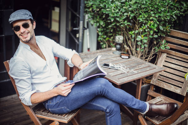 istock Man reading a magazine in cafe 664455150