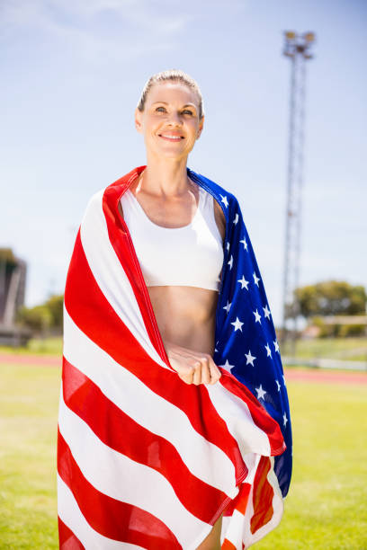istock Happy female athlete wrapped in american flag 664458468