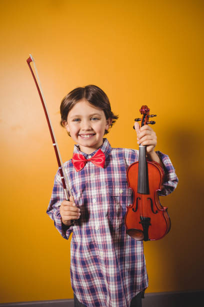 istock A little boy holding a violin 664461494