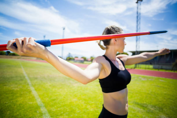 atleta donna in via di lancio di uno strale - javelin foto e immagini stock