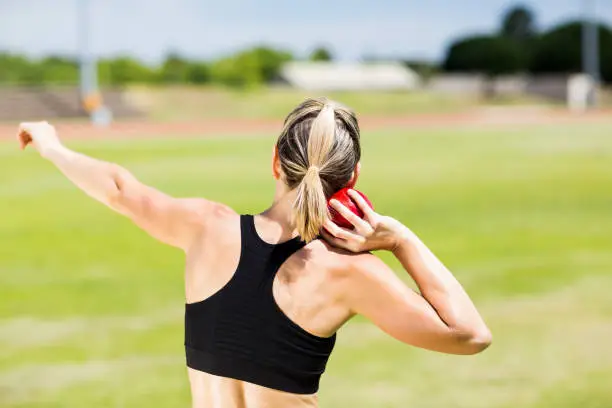 Photo of Rear view of female athlete preparing to throw shot put ball