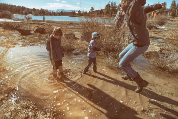 istock Mother jumps into the mud with her sons 664466790
