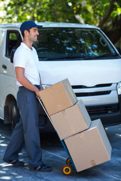 istock Side view of delivery man carrying cardboard boxes 664469754
