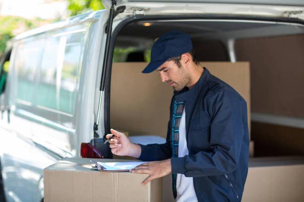 istock Side view of delivery person writing in clipboard 664471204