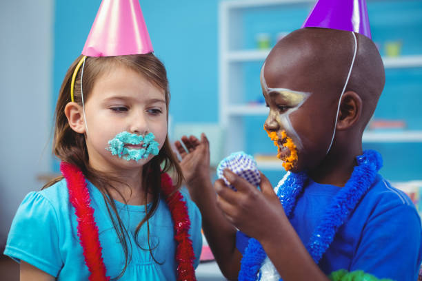 istock Smiling kids with icing on their faces 664473456