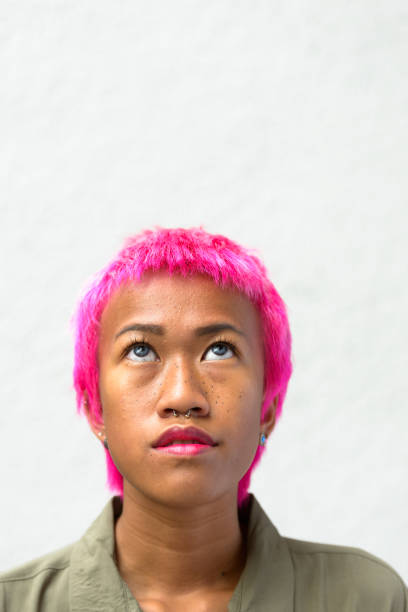 istock Beautiful rebellious young woman with short pink hairstyle thinking while looking up 664504786
