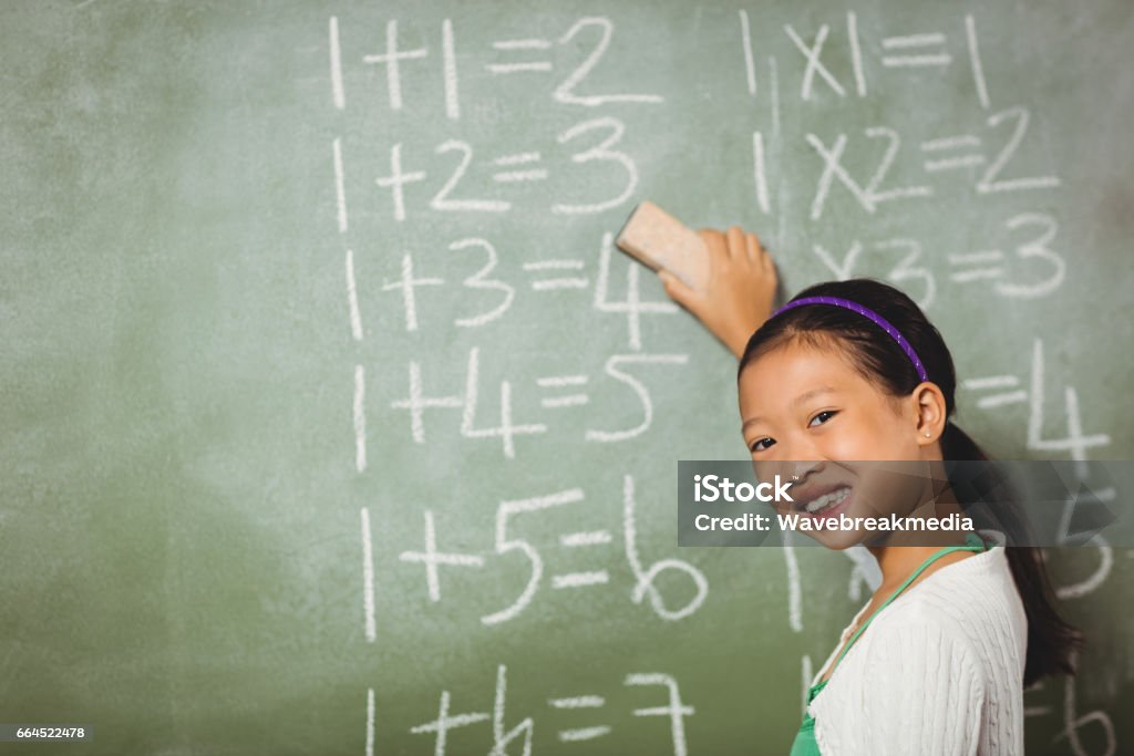 Girl using a sponge for blackboard Girl using a sponge for blackboard at school 8-9 Years Stock Photo