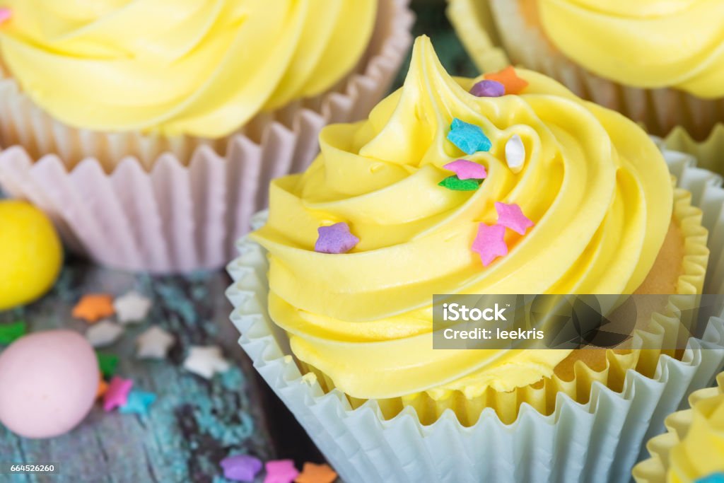 Yellow Easter cupcake with candy and sprinkles Yellow Easter cupcake with candy eggs and sprinkles. Closeup with shallow depth of field. Baked Pastry Item Stock Photo