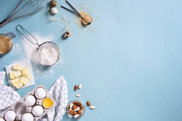 ingredienti sani per la cottura - farina, mandorle, burro, uova, biscotti su un tavolo blu. - baking flour ingredient animal egg foto e immagini stock