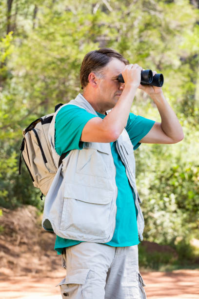 istock senior man is looking in his binoculars 664532600